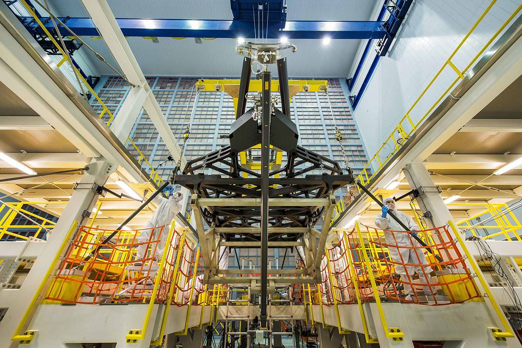 In this photograph, the James Webb Space Telescope's "pathfinder" backplane is hoisted into place in the assembly stand in NASA 