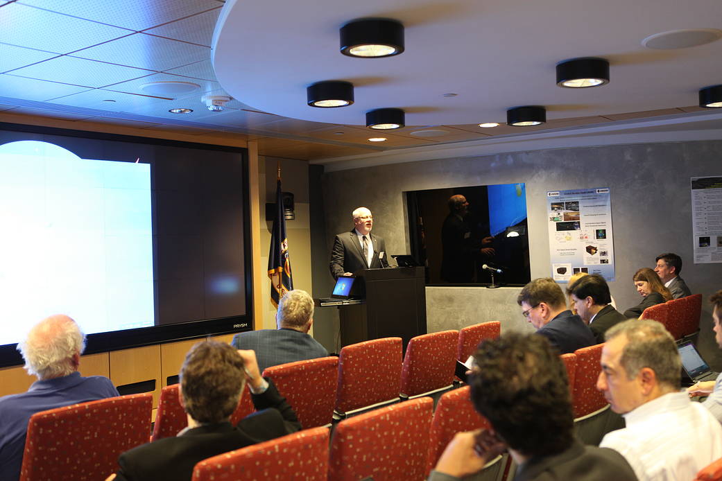 Person talking at podium with people watching