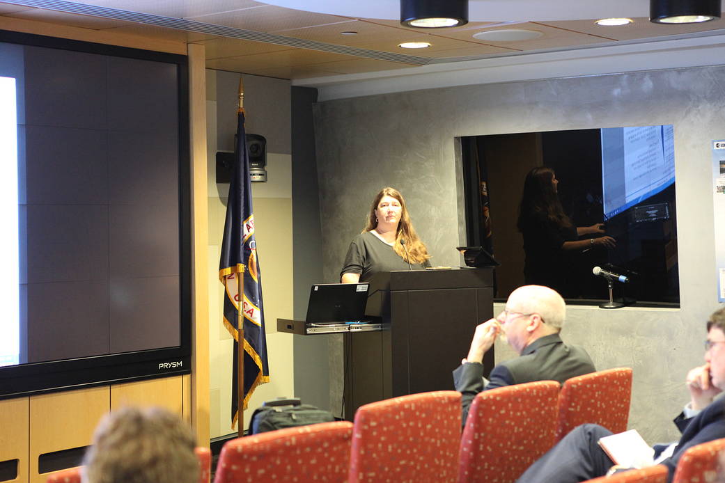 Person talking at podium with people watching
