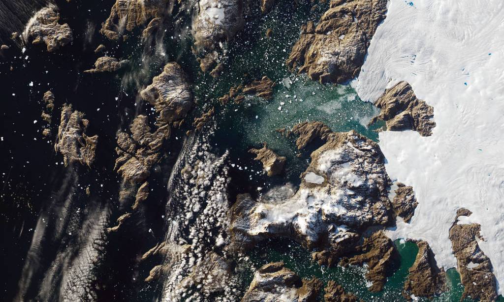 Iceberg Towers Over Greenland Village
