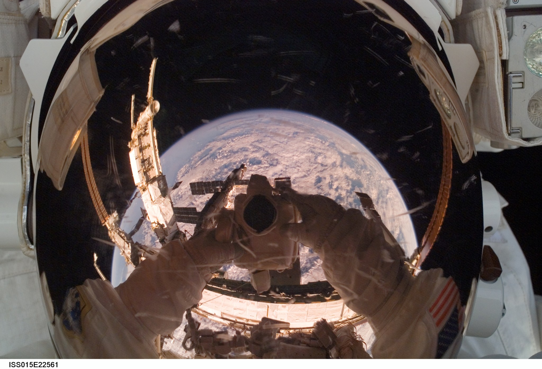 astronaut uses a digital camera to expose a photo of his helmet visor