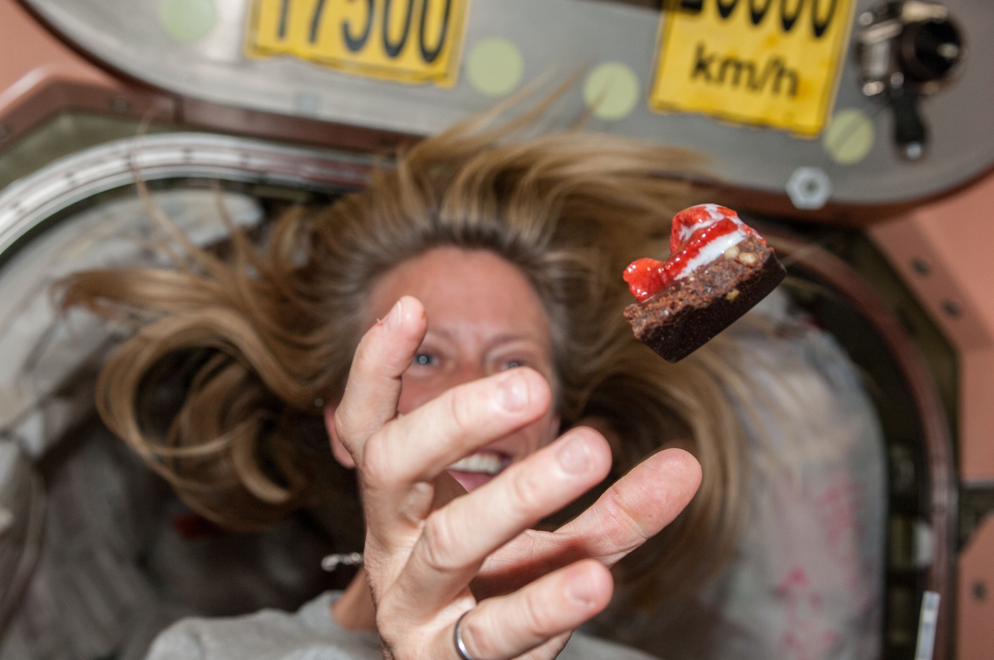 NASA Astronaut floats a piece of food in front of her