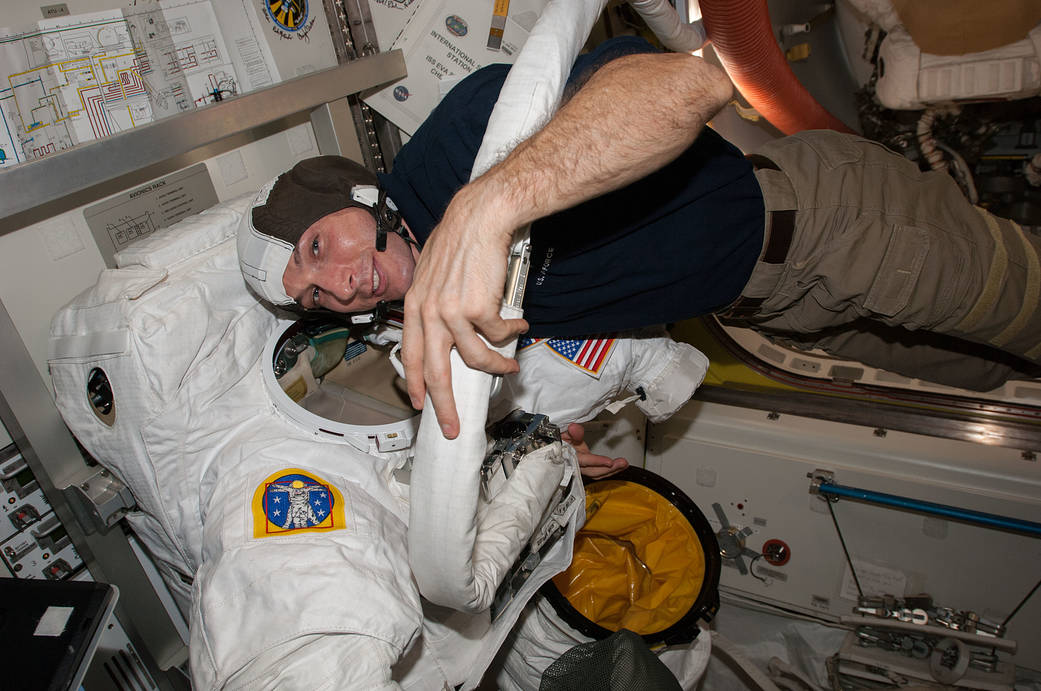 Expedition 38 crew member Mike Hopkins checks out the spacesuit he will wear outside the International Space Station on Saturday