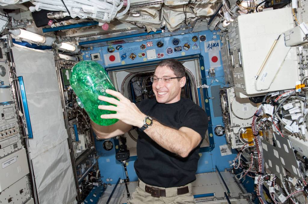 Mike Hopkins Holds a Plastic Container