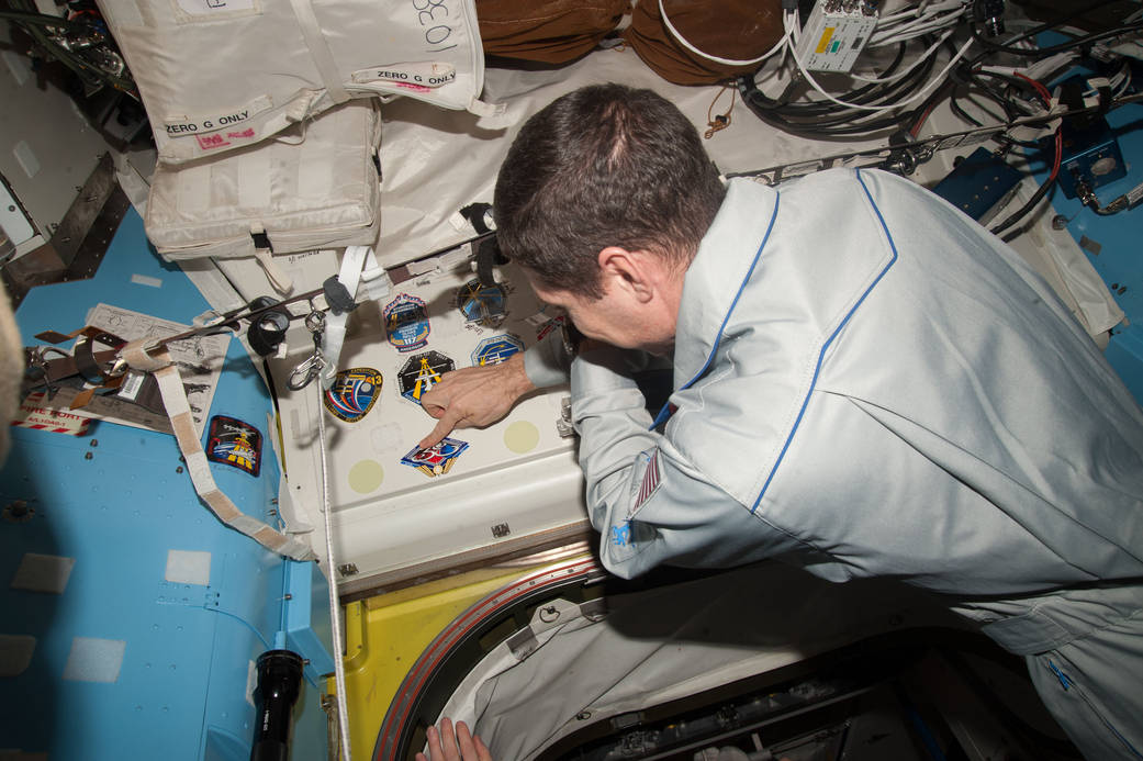 Mike Hopkins Affixes his Mission Decal