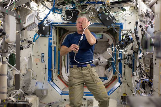 NASA astronaut Steve Swanson, Expedition 40 commander, performs a visual exam using an eye chart (out of frame)