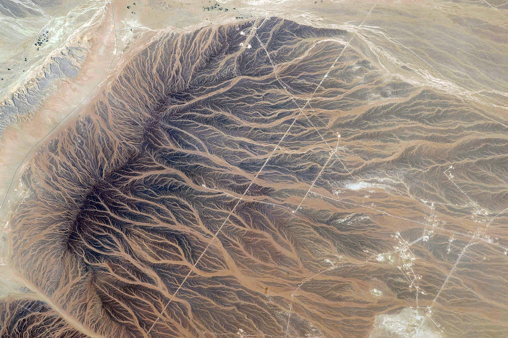 Water tracks on sandy ground with straight lines of roadways crossing the terrain
