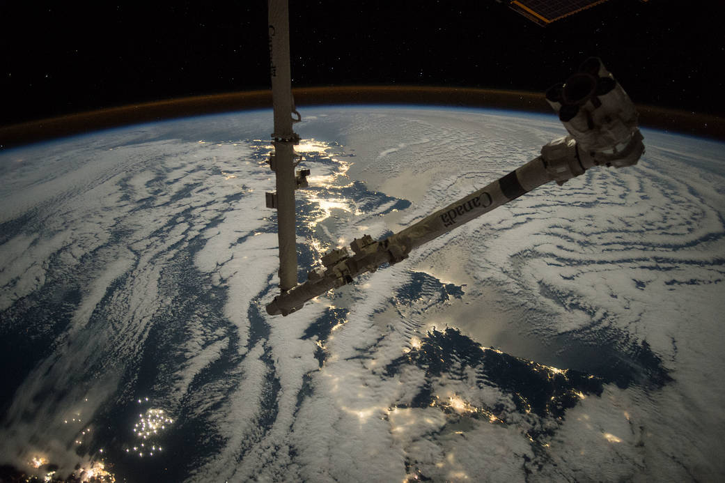 Canadarm2 with lights of Earth at night in background