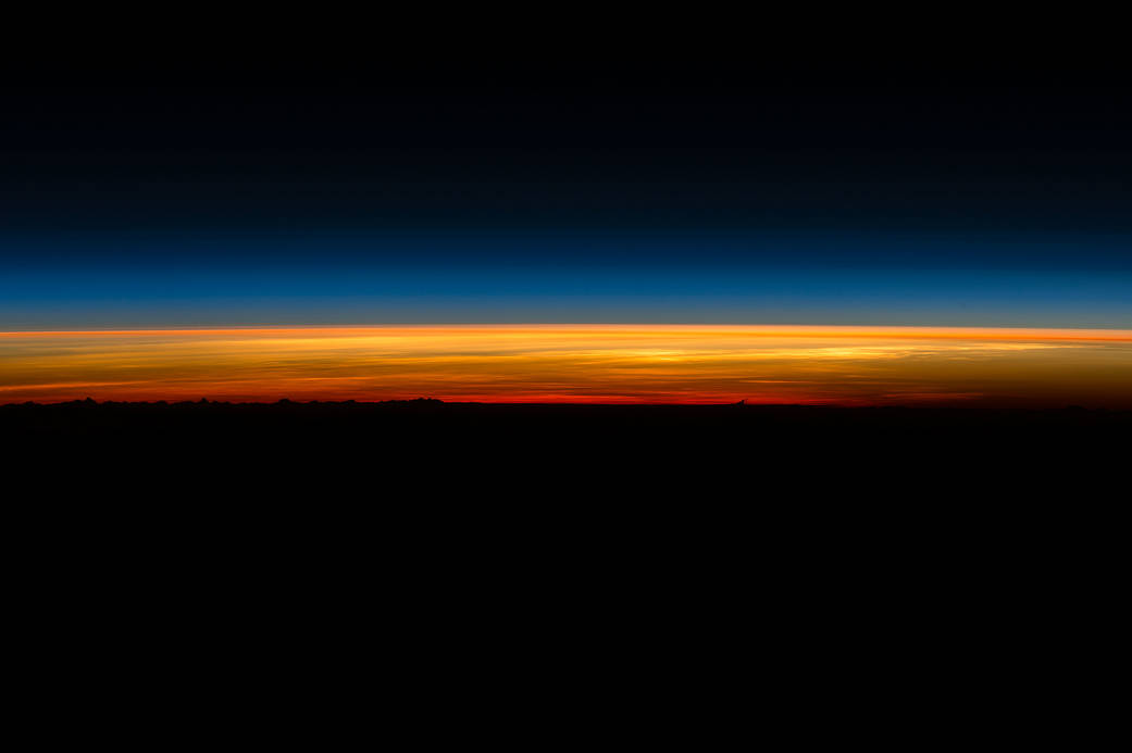 Beginning of sunrise over dark horizon