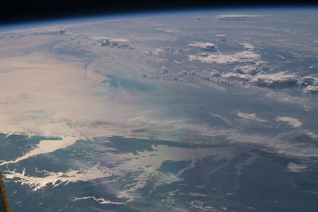 Sunglint over waters of the Chesapeake Bay with clouds overhead, photographed from orbit