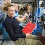 Astronaut Kate Rubins Holds a Reference Guide