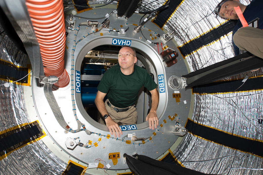 Astronaut floats through hatch of module inside space station