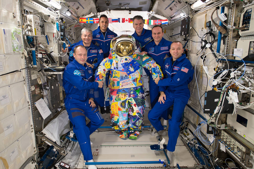 The Expedition 53 Crew Poses with a Hand-Painted Spacesuit