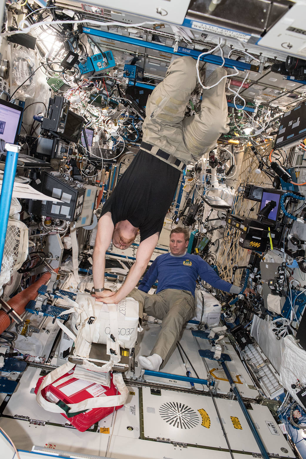 Astronaut Alexander Gerst practices CPR as cosmonaut Sergey Prokopev looks on