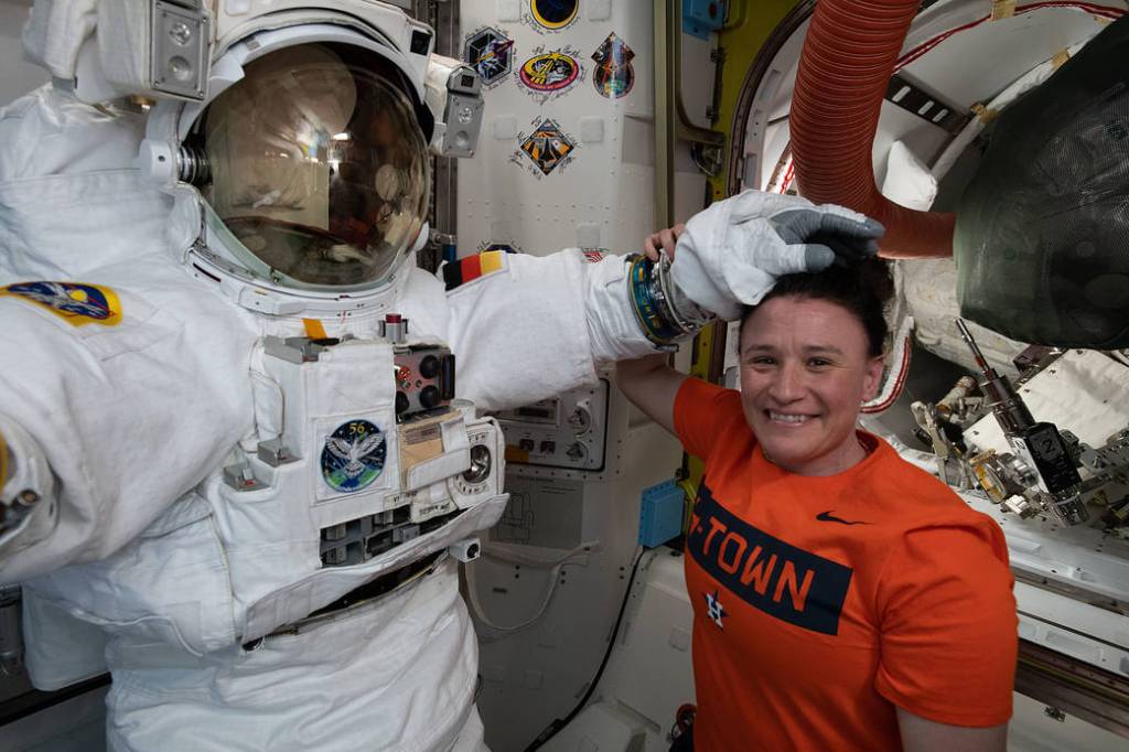 NASA astronaut Serena Auñón-Chancellor poses with a U.S. spacesuit