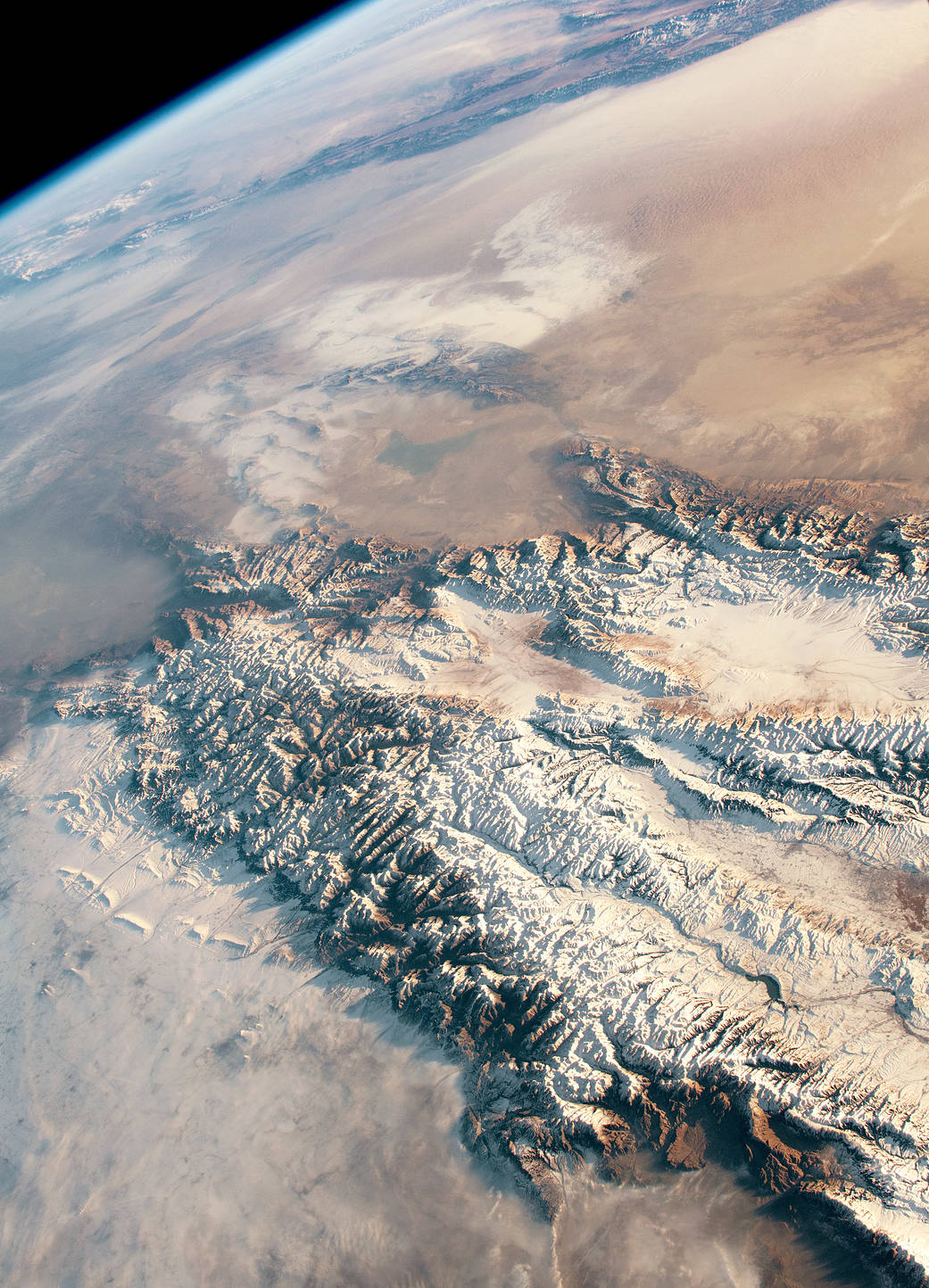 View from orbit of snowy mountain range and desert