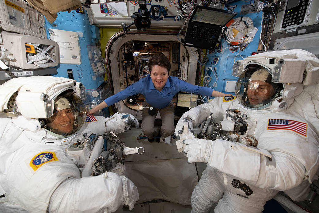 Astronaut Anne McClain assists fellow astronauts Christina Koch and Nick Hague