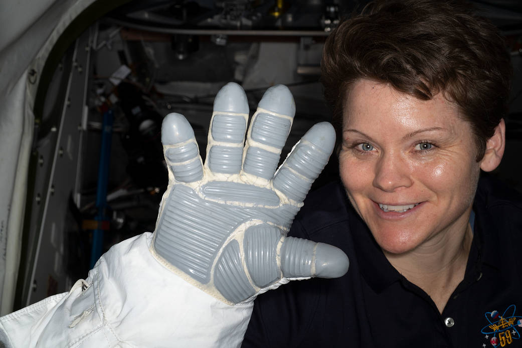 NASA astronaut Anne McClain displays a spacesuit glove