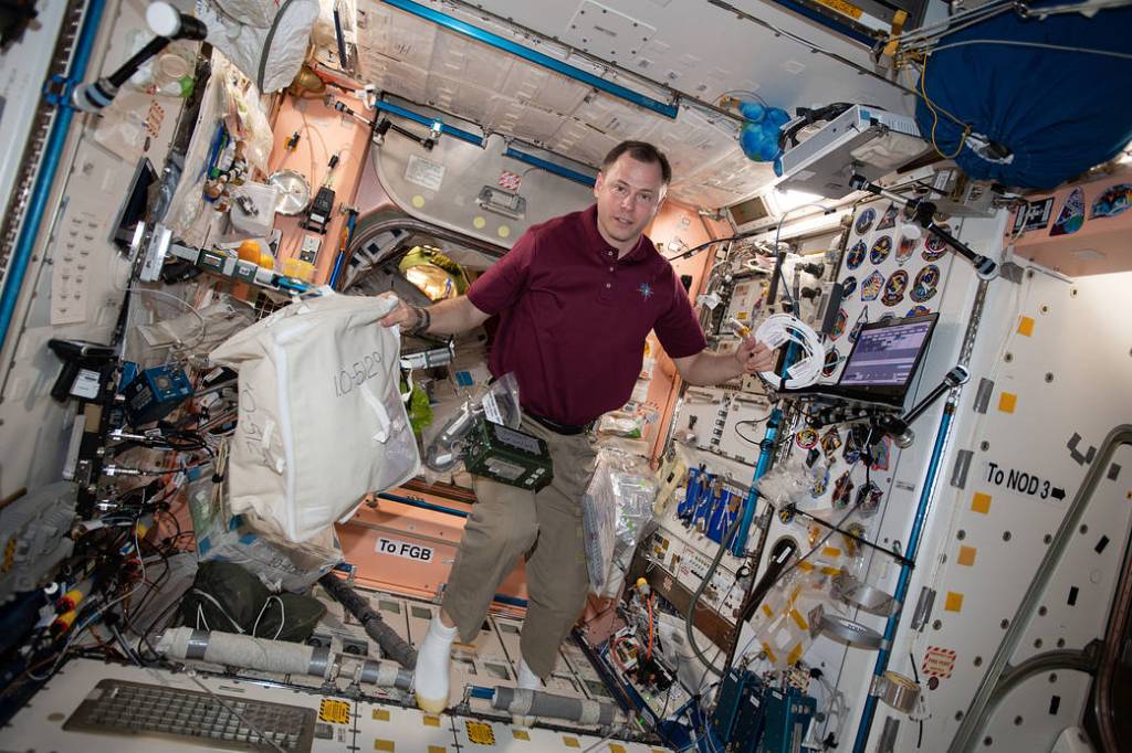 Astronaut Nick Hague sets computer hardware
