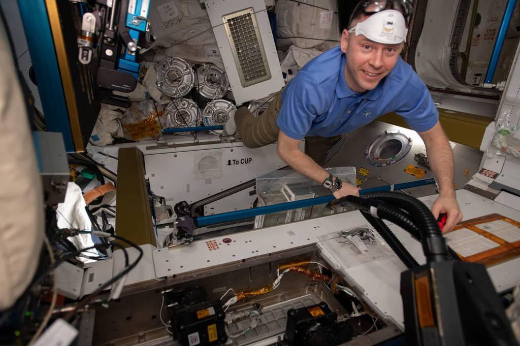 NASA astronaut Nick Hague removes bacteria filters