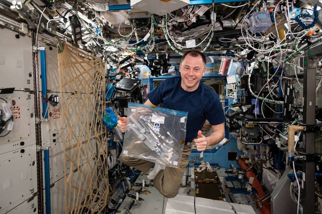 NASA astronaut Nick Hague works with a student experiment