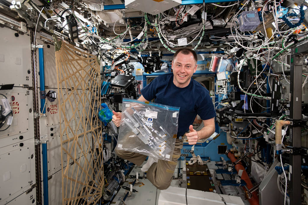 NASA astronaut Nick Hague works with a student experiment