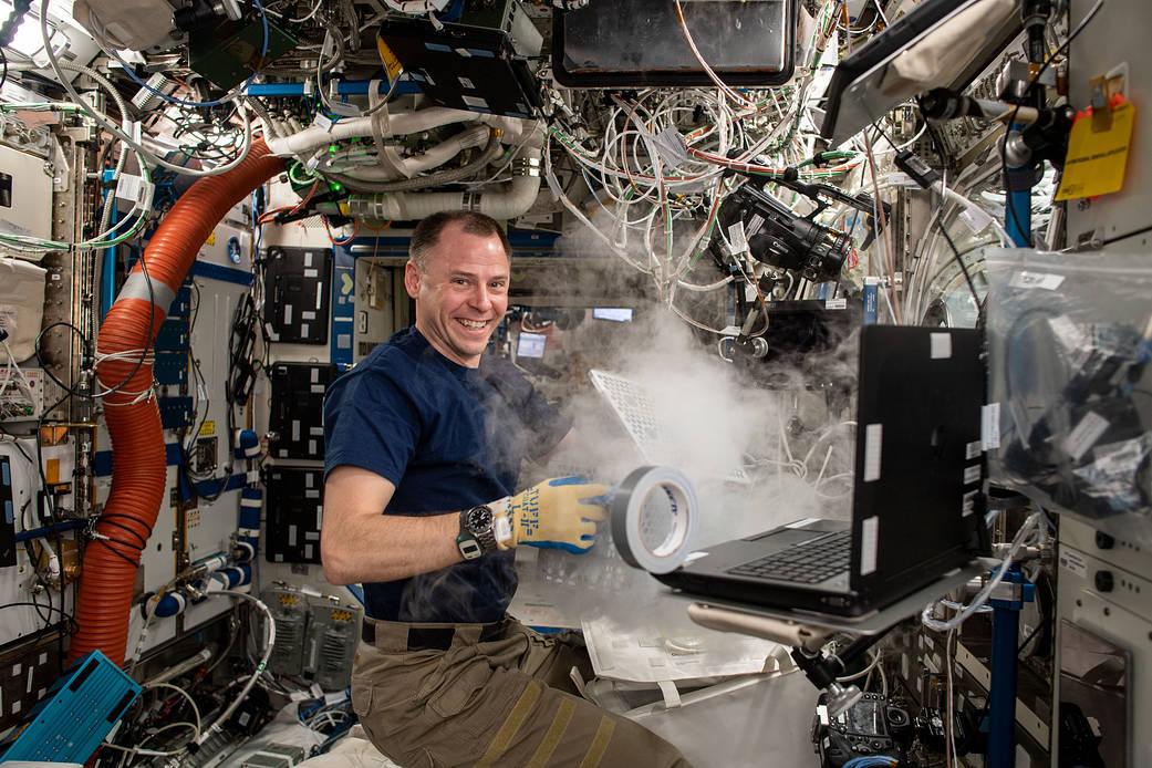 Astronaut Nick Hague Works on a Science Freezer