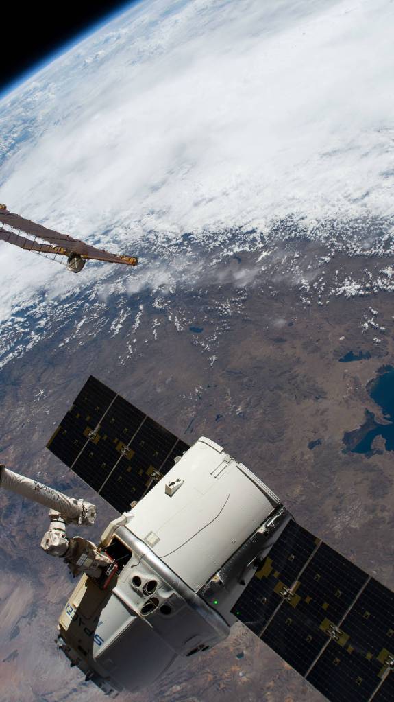The SpaceX Dragon cargo craft in the grips of the Canadarm2