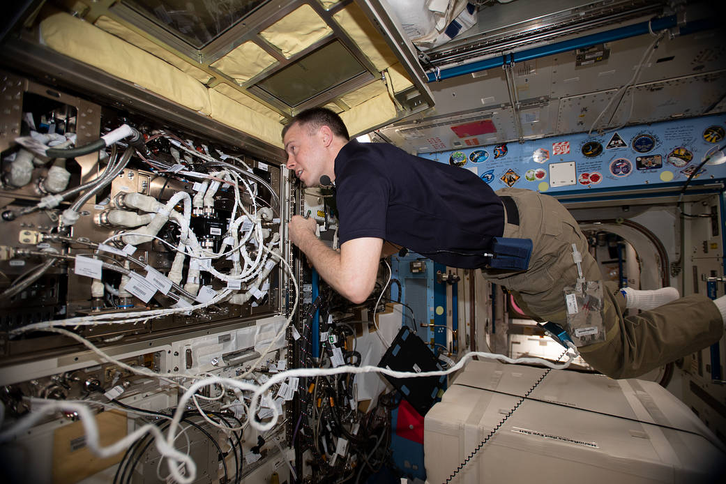 NASA astronaut Nick Hague works inside the Kibo module