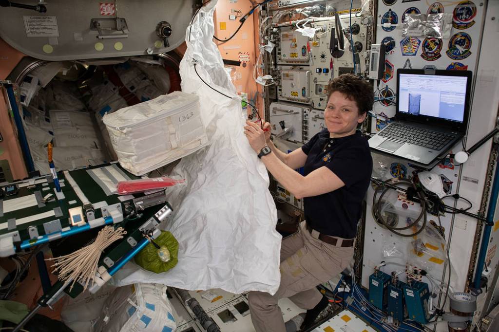 NASA astronaut Anne McClain assembles a hygiene cover