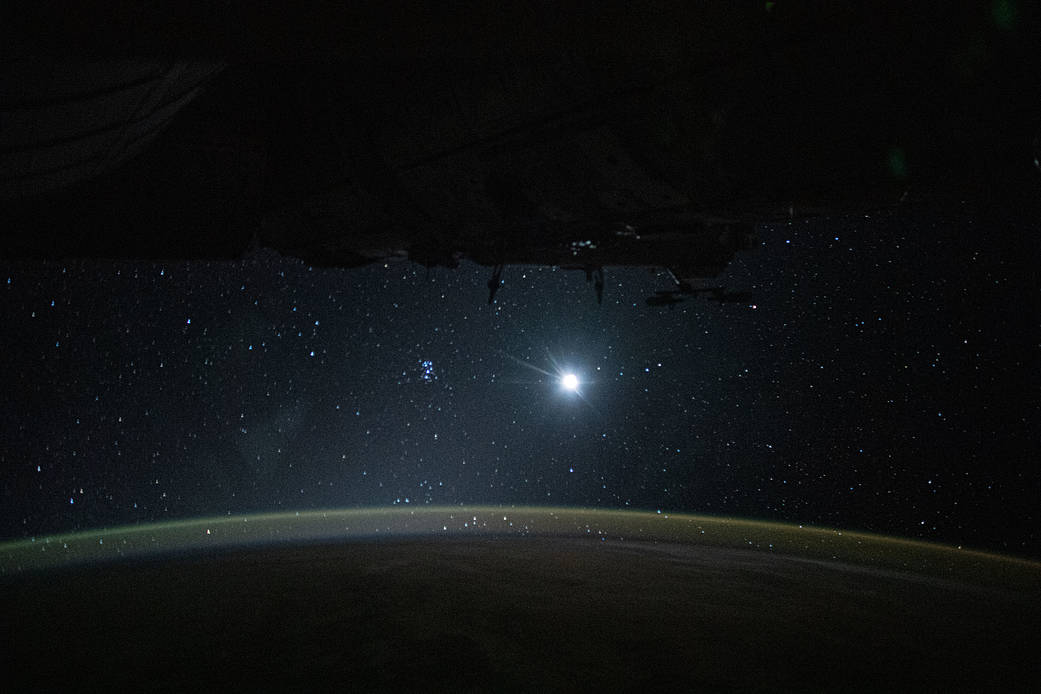 Earth's atmospheric glow, the Moon and a starry orbital nighttime background