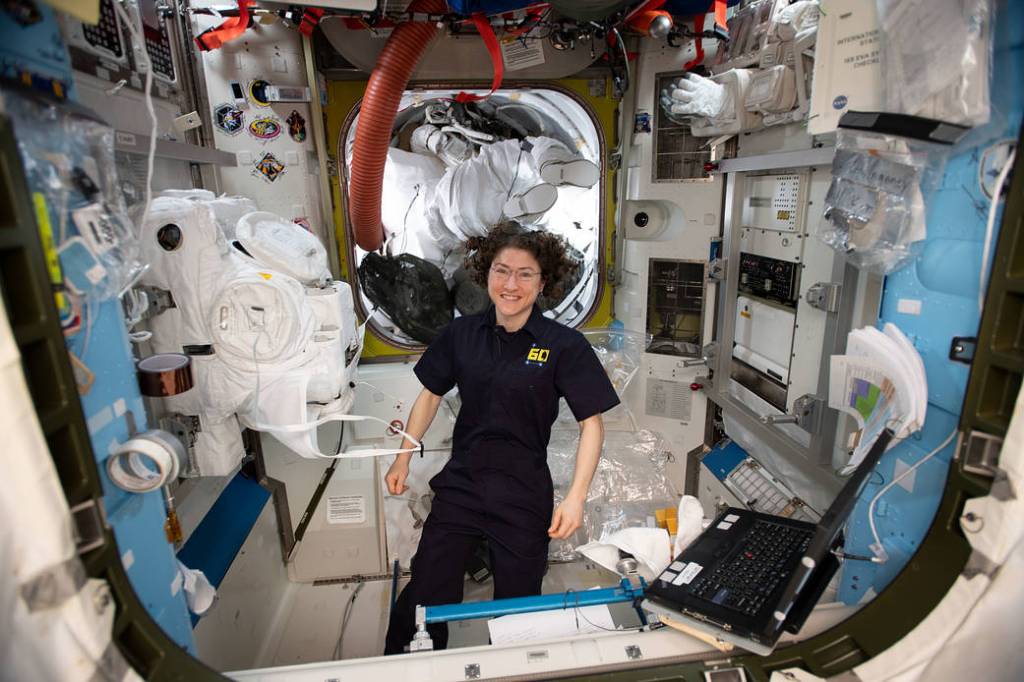 Flight Engineer Christina Koch configures a pair spacesuits