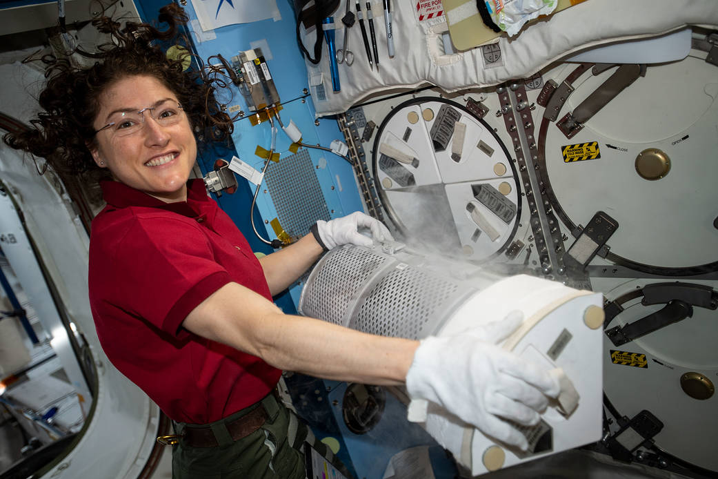 Christina Koch conducts science operations using a science freezer