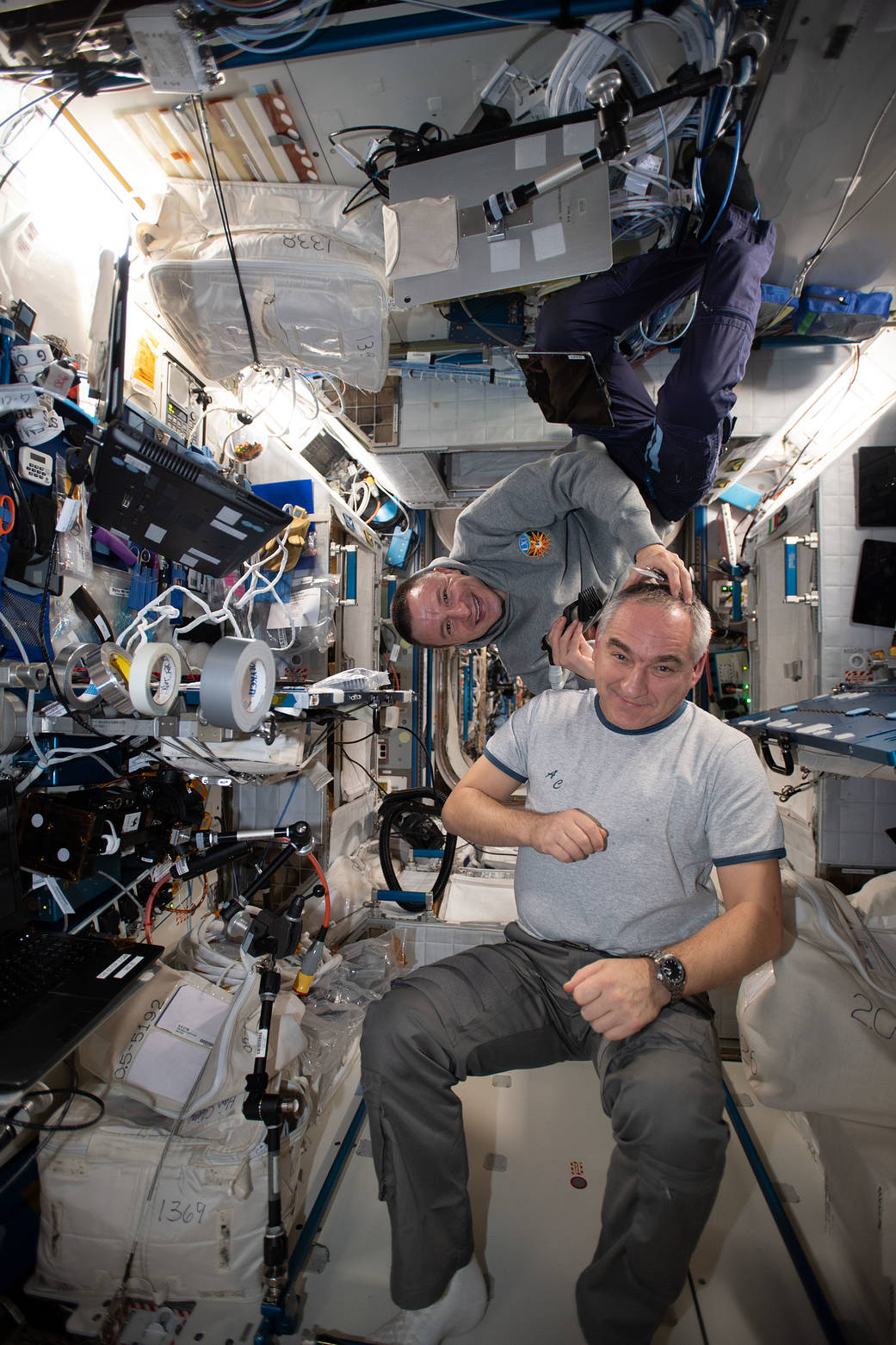 Astronaut Andrew Morgan trims the hair of cosmonaut Alexander Skvortsov