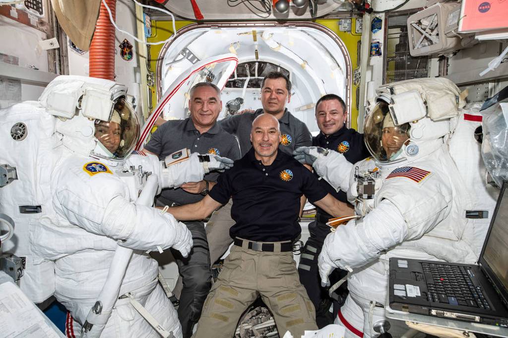 The Expedition 61 crew pauses for a photo as Jessica Meir and Christina Koch prepare to exit the space station to begin the first all-female spacewalk in history