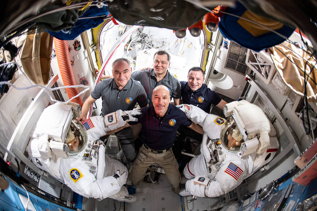 Spacewalkers Jessica Meir and Christina Koch pose with their Expedition 61 crewmates