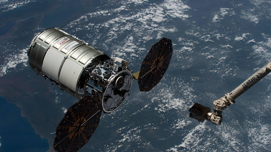 The Canadarm2 reaches out to capture the Cygnus space freighter