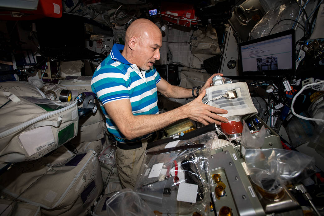 Commander Luca Parmitano installs new components in a life support system
