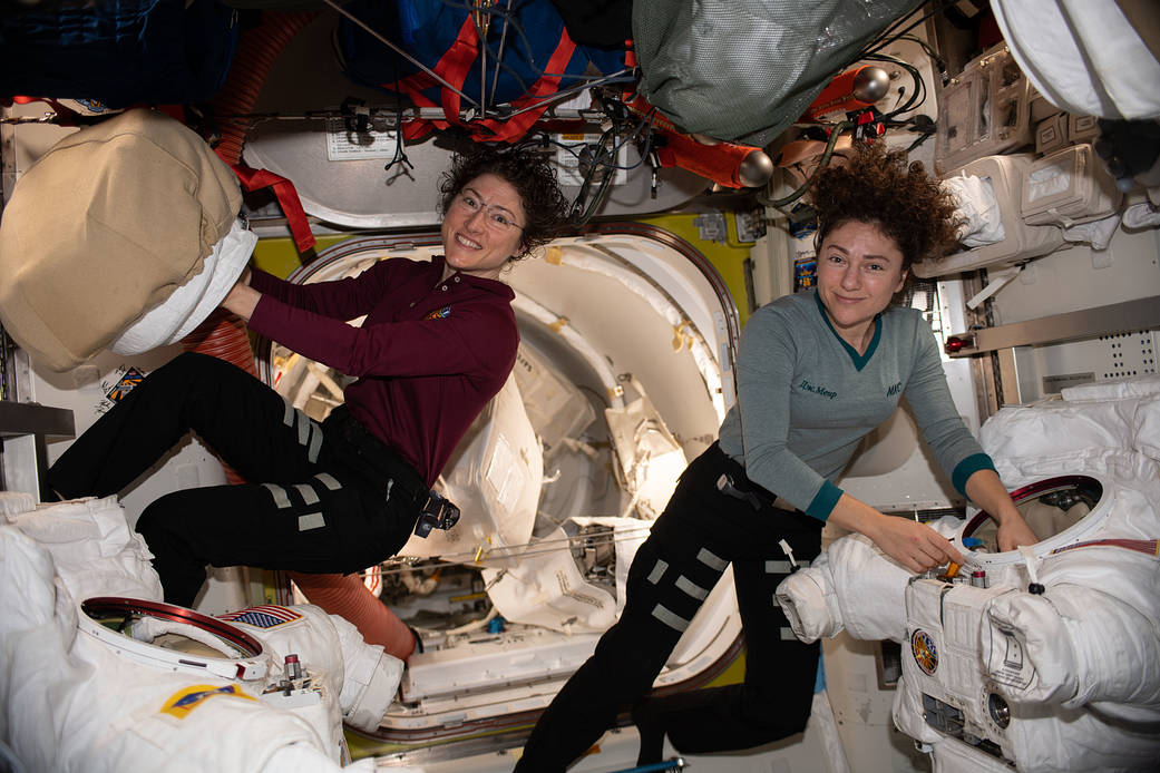 Astronauts Christina Koch and Jessica Meir work on U.S. spacesuits