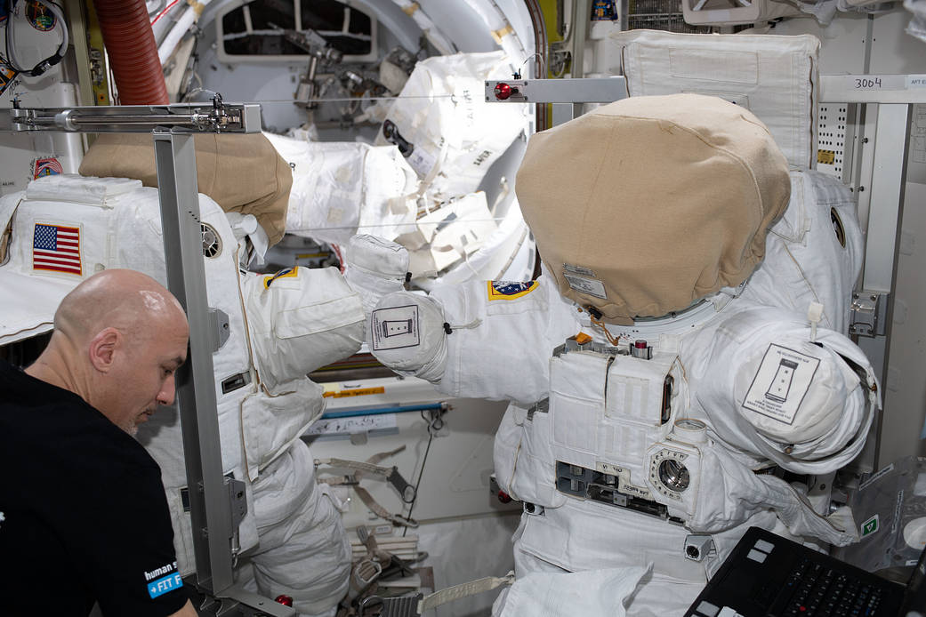 Commander Luca Parmitano works on U.S. spacesuits