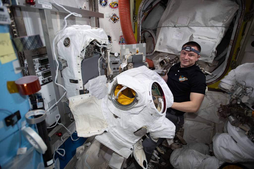 NASA astronaut Andrew Morgan works on U.S. spacesuit components