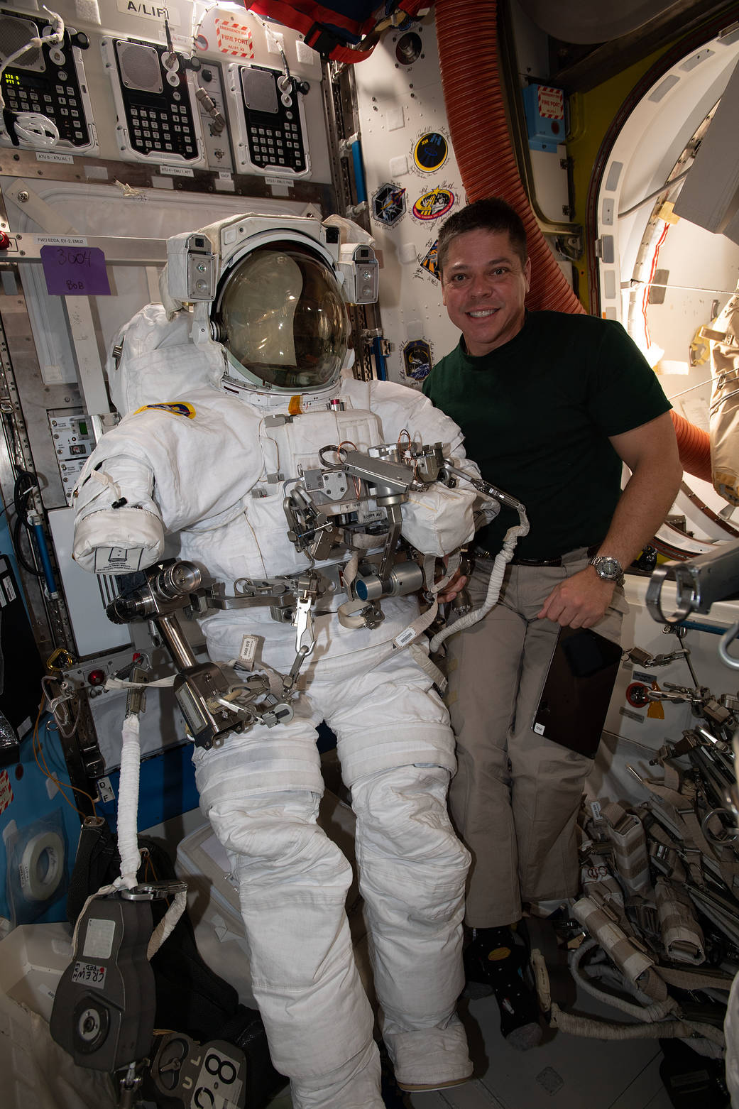 Expedition 63 Flight Engineer Bob Behnken poses with a U.S. spacesuit