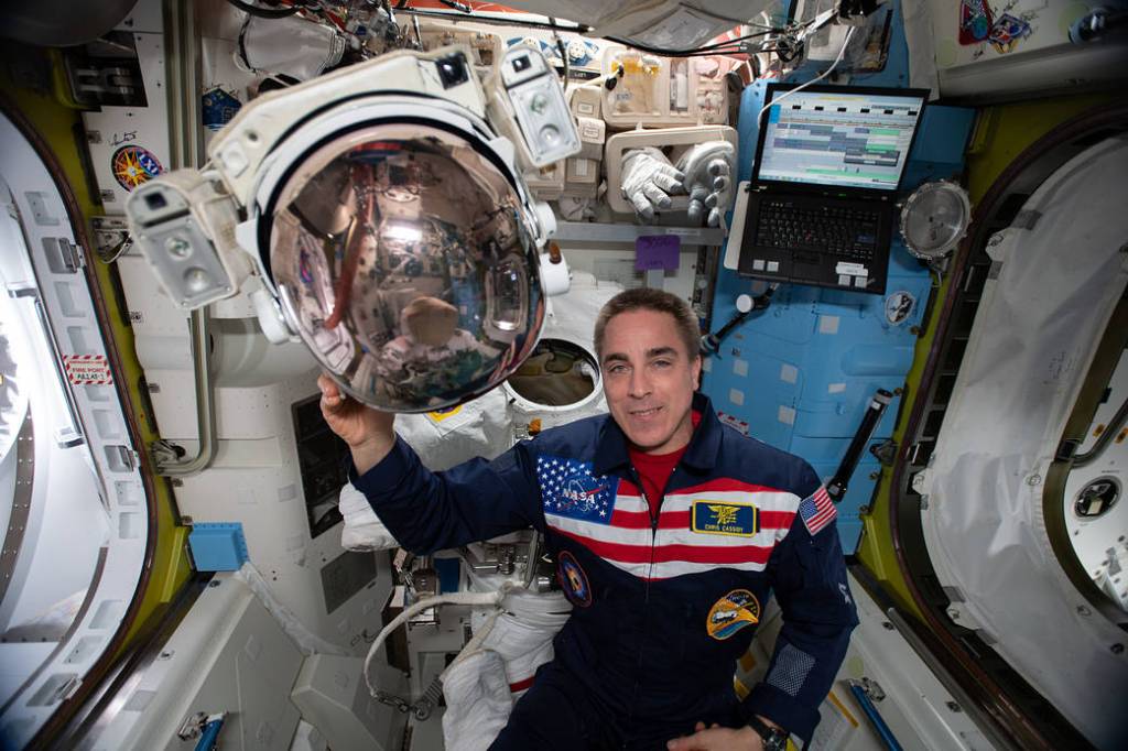 Expedition 63 Commander Chris Cassidy shows off a spacesuit helmet