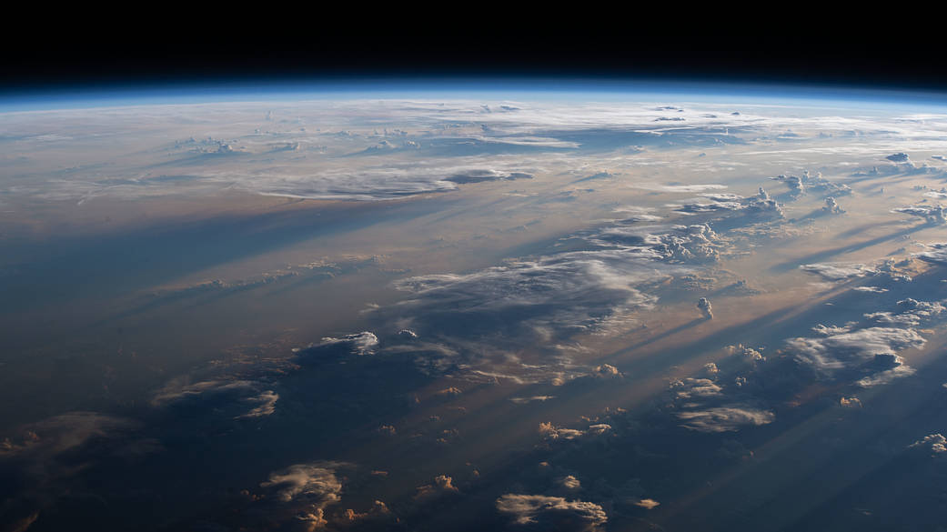 Sunrise casts long shadows over a cloudy Philippine Sea