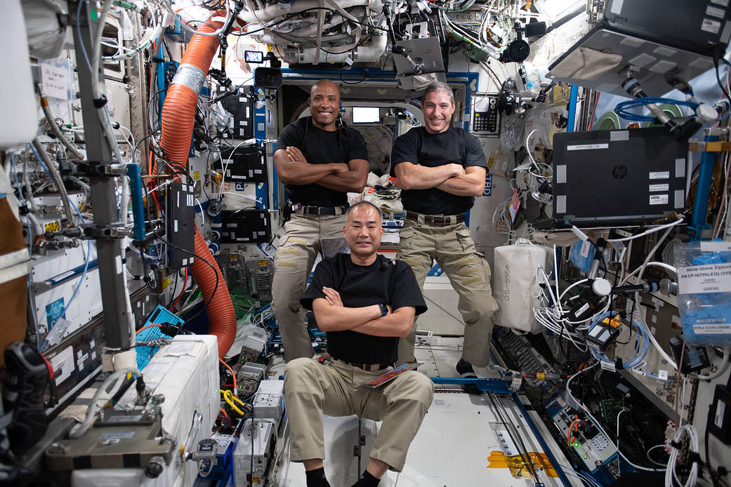 Three astronauts pose for a playful portrait