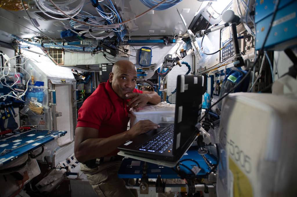 Astronaut Victor Glover reviews research procedures on a computer