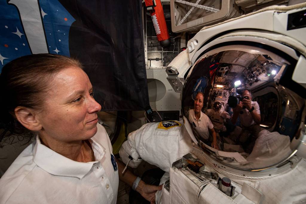 NASA astronaut Shannon Walker is reflected in a U.S. spacesuit helmet