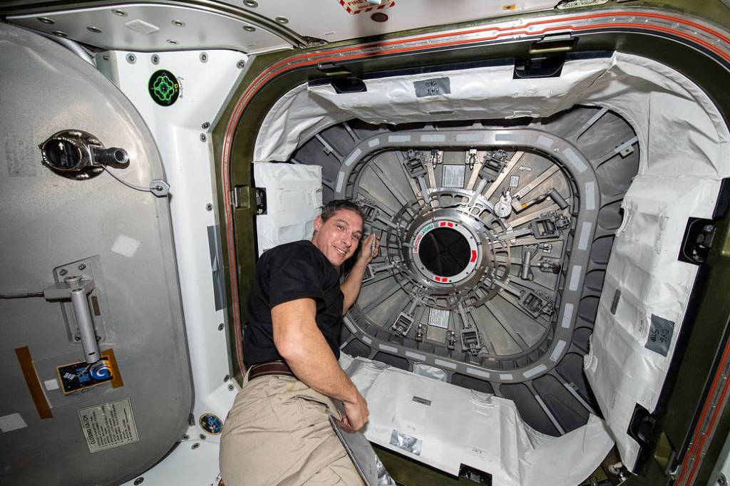 Astronaut Michael Hopkins closes the Cygnus space freighter hatch