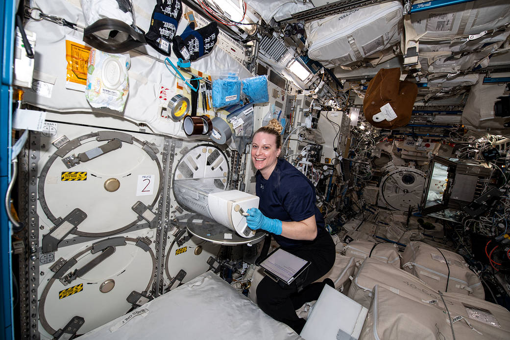 Astronaut Kate Rubins loads biological samples into a science freezer