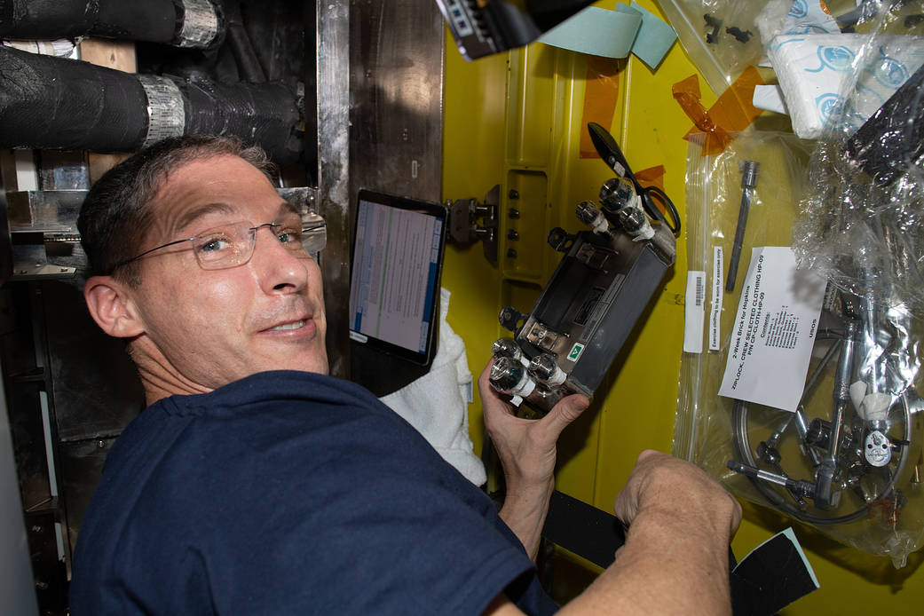 Flight Engineer Michael Hopkins works on U.S. spacesuit maintenance